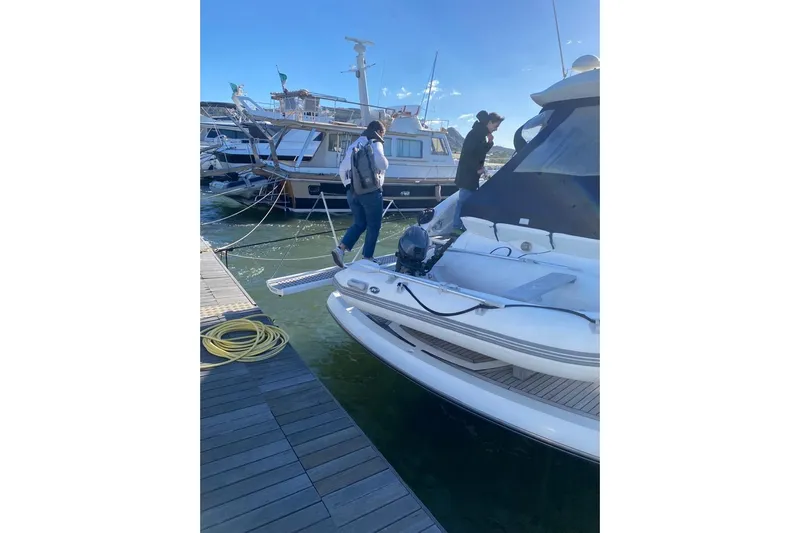  Yacht Photos Pics Two people boarding a 2006 Sunseeker Portofino 47 yacht at a marina.