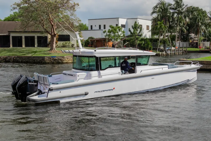  Yacht Photos Pics 2024 Axopar 37XC CROSS CABIN cruising on a scenic waterway.
