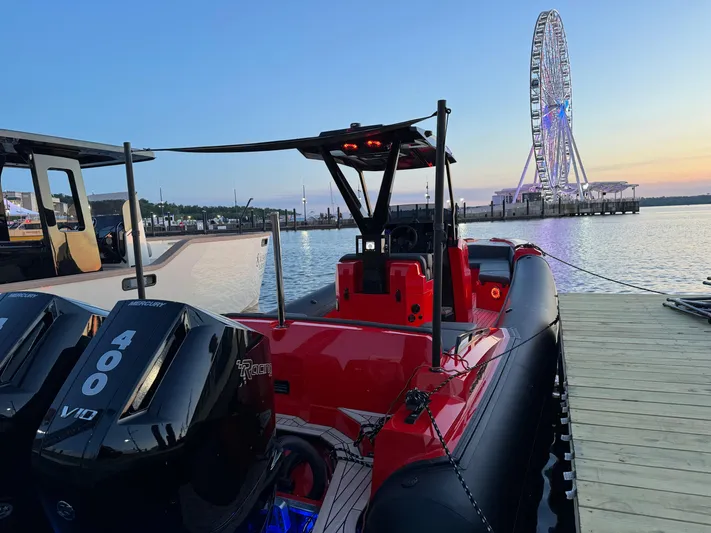  Yacht Photos Pics 2024 SuperRib Open 30 boat docked with Ferris wheel in background at sunset.