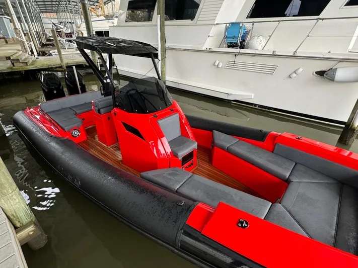  Yacht Photos Pics Red and black 2024 SuperRib Open 30 boat docked in a marina.