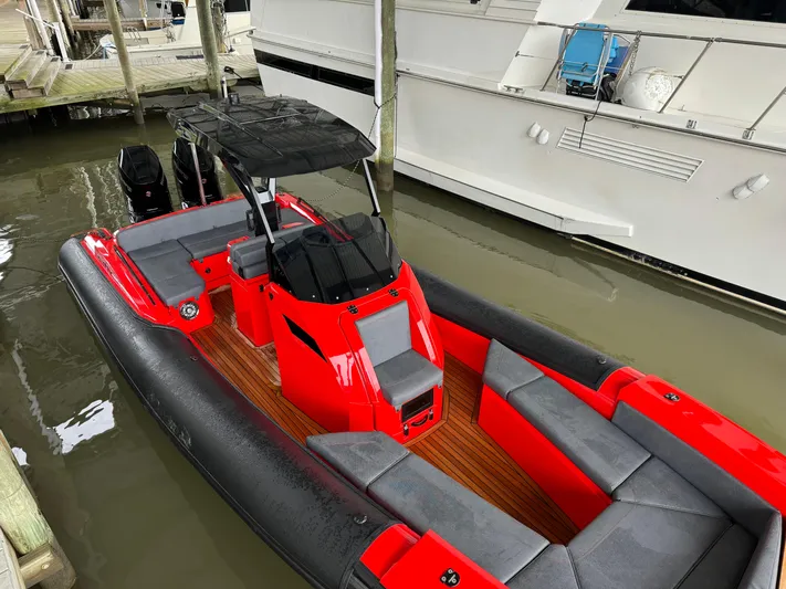  Yacht Photos Pics 2024 SuperRib Open 30 boat docked, featuring red and black design with spacious seating.
