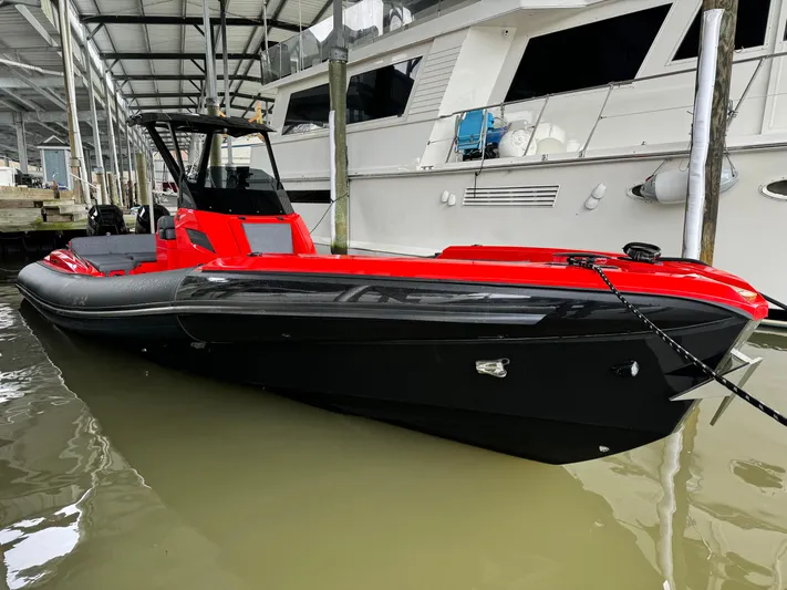  Yacht Photos Pics 2024 SuperRib Open 30 boat docked, featuring a sleek red and black design.