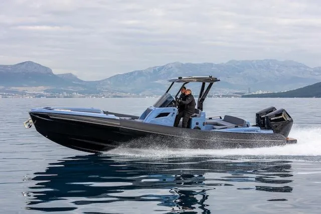  Yacht Photos Pics 2025 SuperRib Open 30 speedboat cruising on calm water with mountainous backdrop.