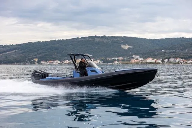  Yacht Photos Pics 2025 SuperRib Open 30 speeding on water with scenic hillside background.