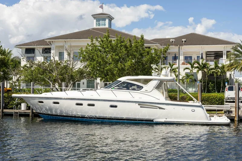  Yacht Photos Pics 2000 Tiara Yachts 5200 Express docked near a waterfront property, under a clear blue sky.