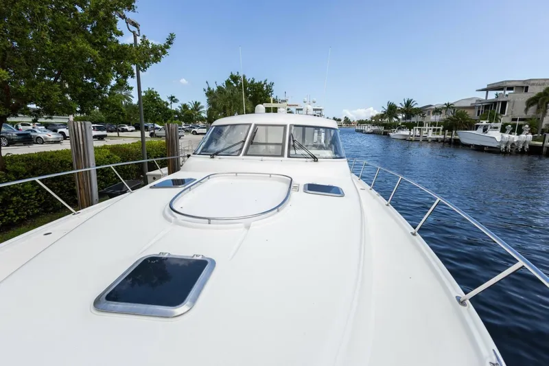  Yacht Photos Pics 2000 Tiara Yachts 5200 Express on a serene waterway, showcasing sleek design and luxury.