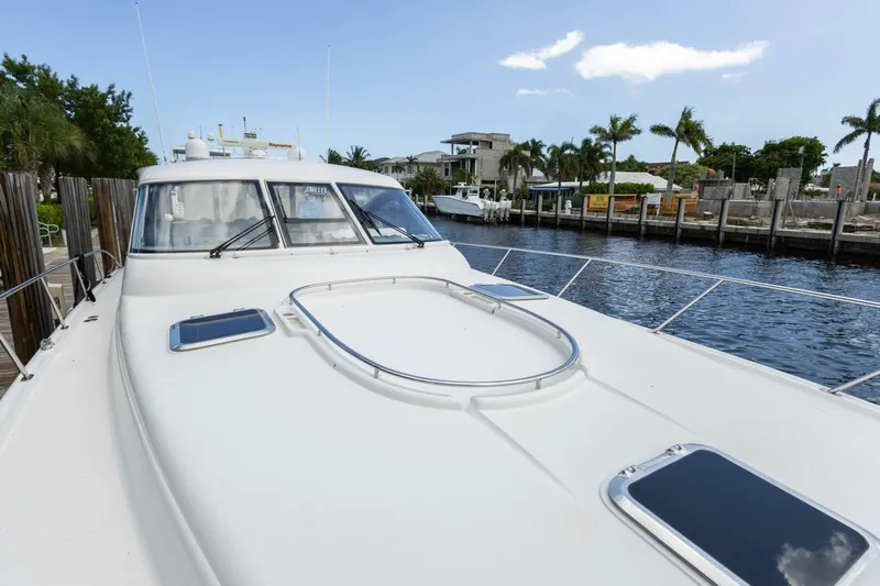  Yacht Photos Pics 2000 Tiara Yachts 5200 Express docked by waterfront homes, clear sky.