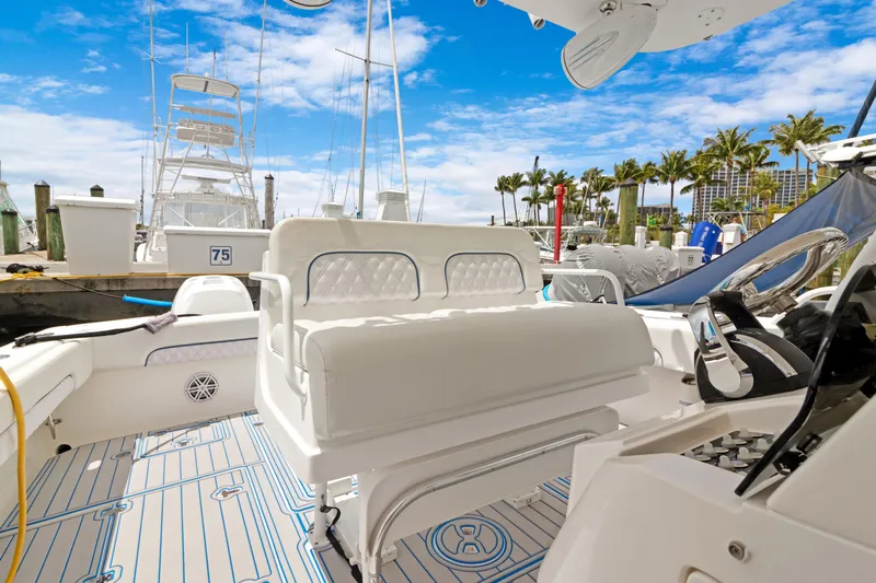  Yacht Photos Pics 2004 Intrepid 377 Walkaround boat interior with seating, docked under a clear blue sky.