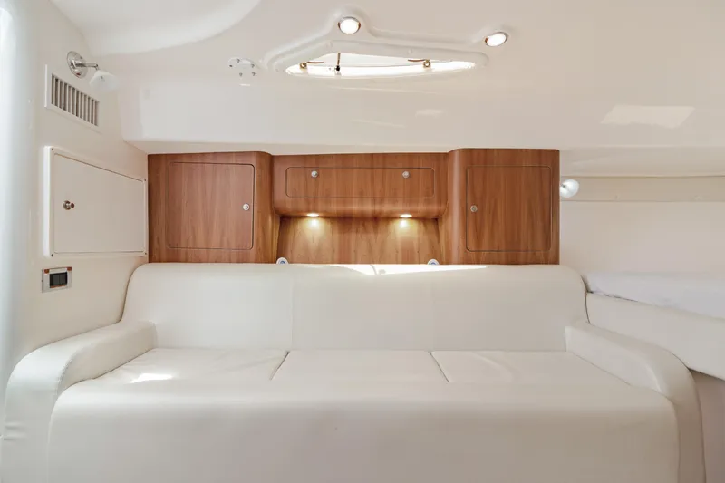  Yacht Photos Pics Interior of 2004 Intrepid 377 Walkaround with white sofa and wooden cabinets.