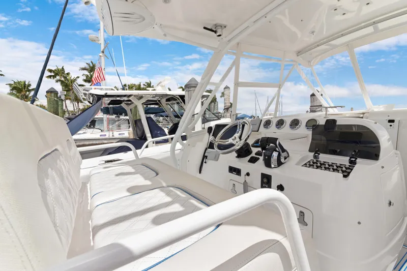  Yacht Photos Pics 2004 Intrepid 377 Walkaround boat interior with steering console and seating, docked at marina.