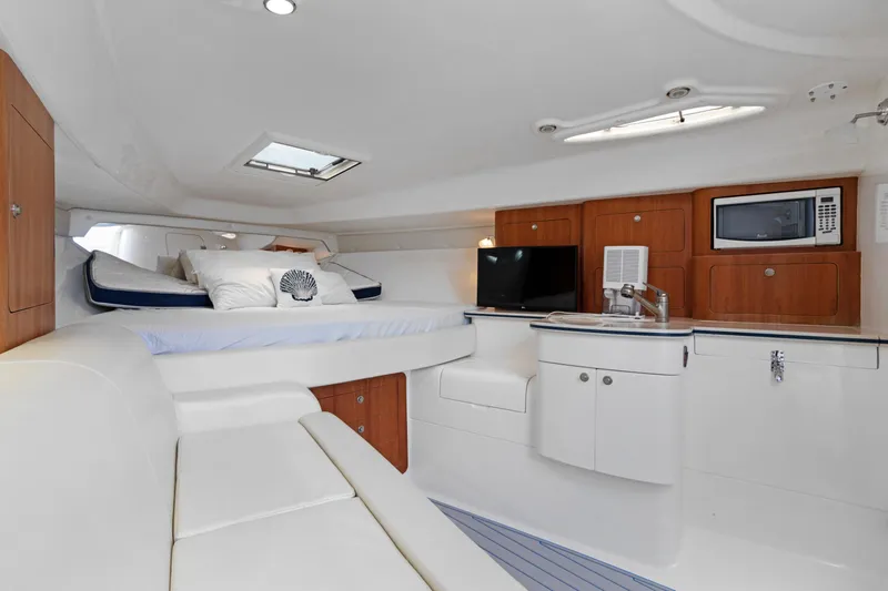  Yacht Photos Pics 2004 Intrepid 377 Walkaround cabin interior with bed, kitchenette, and seating area.