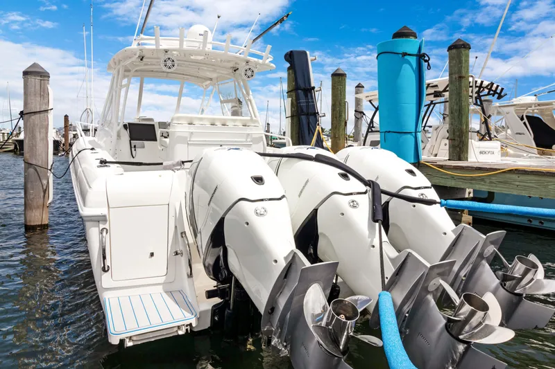  Yacht Photos Pics 2004 Intrepid 377 Walkaround boat with triple outboard engines docked at marina.