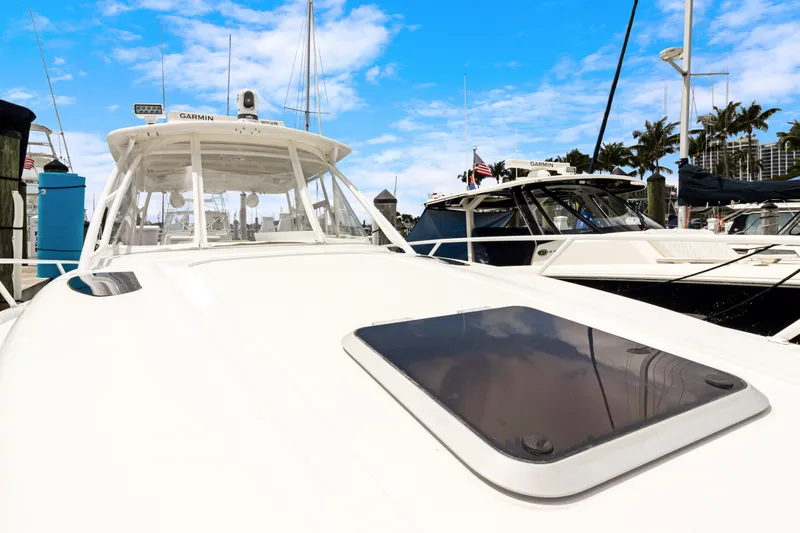  Yacht Photos Pics 2004 Intrepid 377 Walkaround boat docked at marina under blue sky.