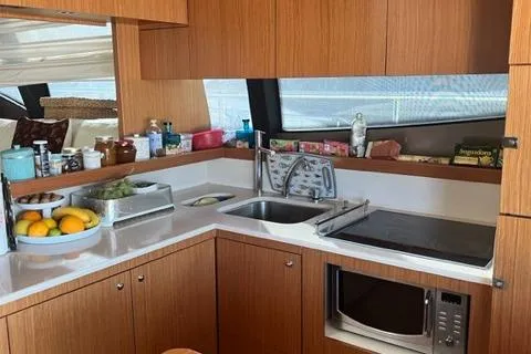  Yacht Photos Pics Luxurious kitchen interior of 2008 Ferretti Yachts 592, featuring modern appliances and wooden cabinetry.