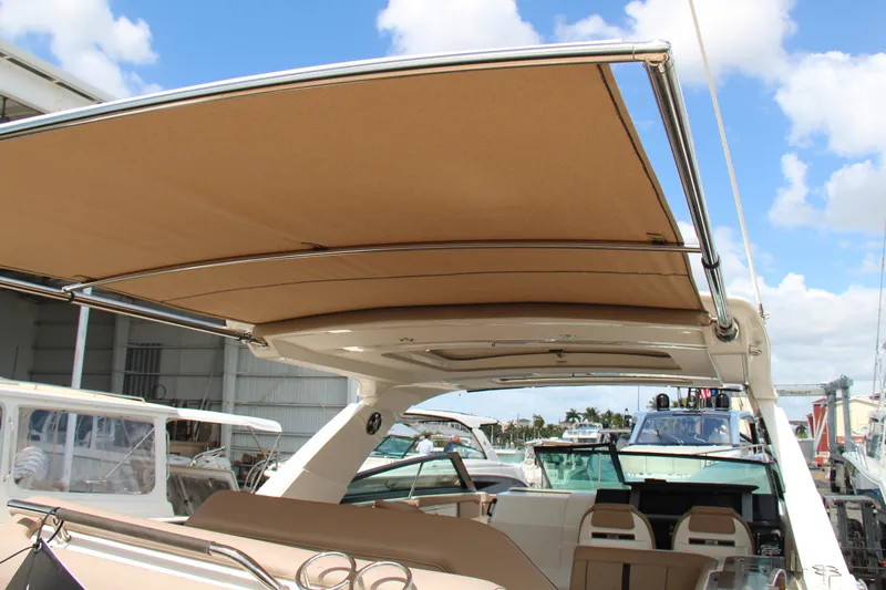  Yacht Photos Pics 2019 Sea Ray SLX 400 boat with tan canopy, docked under blue sky.