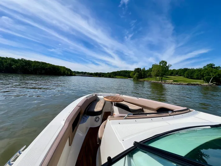  Yacht Photos Pics 2019 Sea Ray SLX 400 cruising on a serene lake under a clear blue sky.