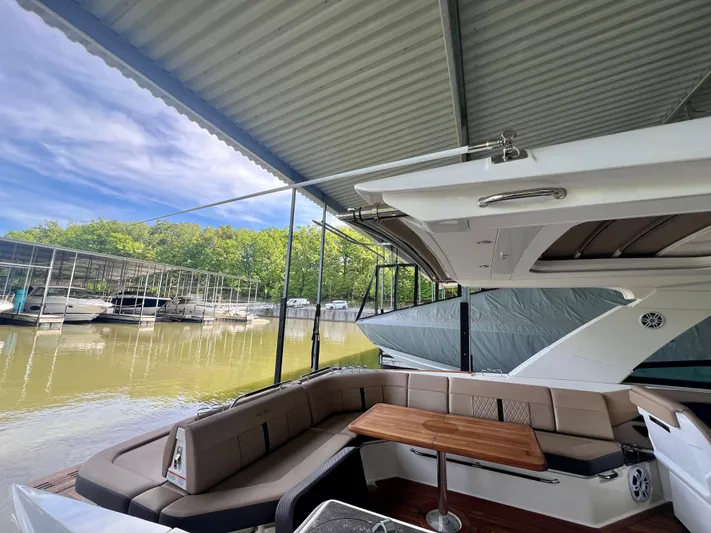  Yacht Photos Pics 2019 Sea Ray SLX 400 yacht interior with seating and table, docked under a covered marina.