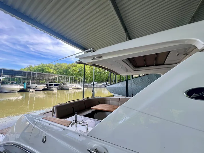  Yacht Photos Pics 2019 Sea Ray SLX 400 yacht docked under a canopy, featuring a spacious seating area.