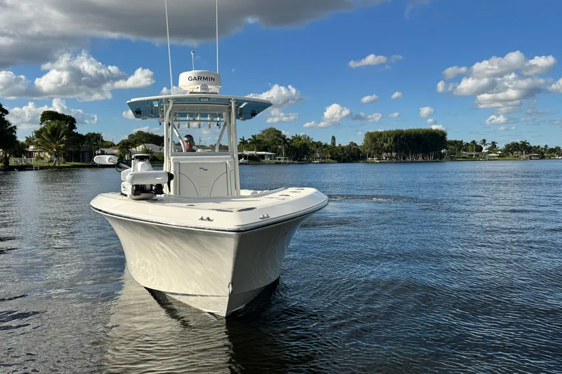  Yacht Photos Pics 2024 SeaVee 290B boat cruising on a calm lake under a blue sky.