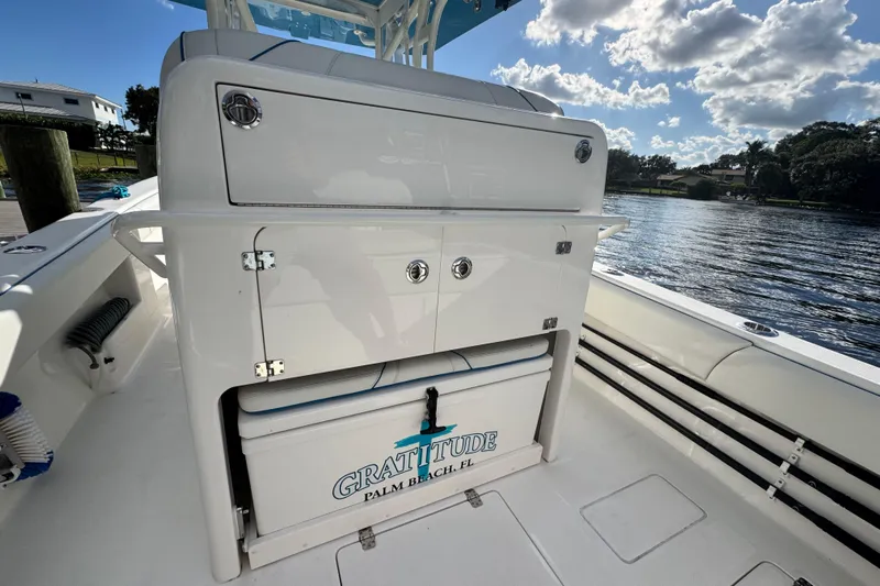  Yacht Photos Pics 2024 SeaVee 290B boat interior with storage and cooler, docked by a scenic waterfront.