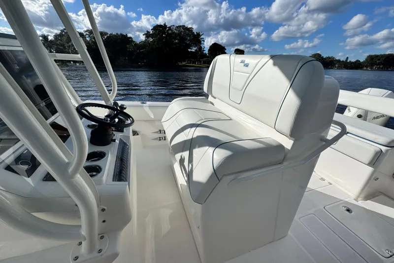  Yacht Photos Pics 2024 SeaVee 290B boat interior with white seating and steering wheel, on a sunny day.