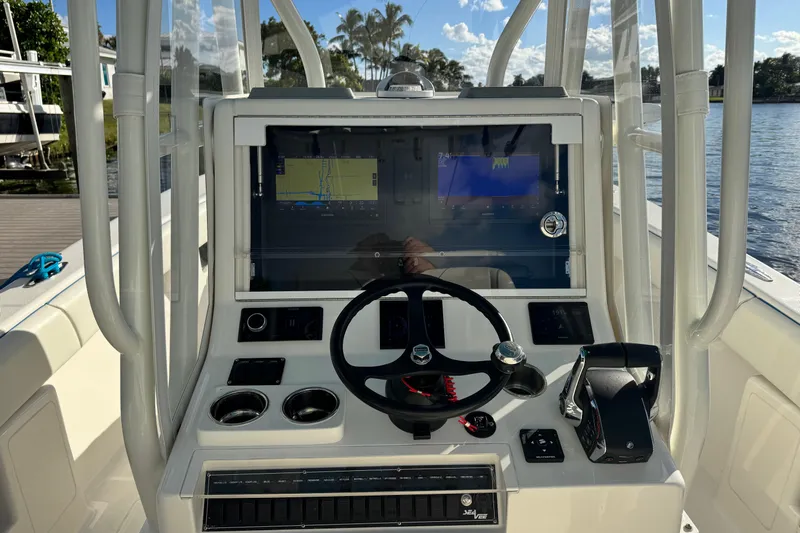  Yacht Photos Pics 2024 SeaVee 290B boat dashboard with navigation screens and steering wheel.