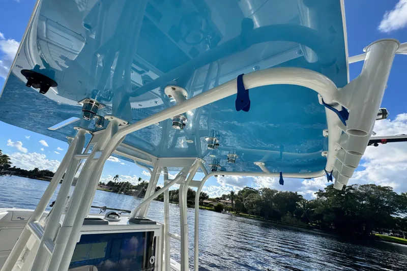  Yacht Photos Pics 2024 SeaVee 290B boat with blue canopy, rod holders, and scenic water view.