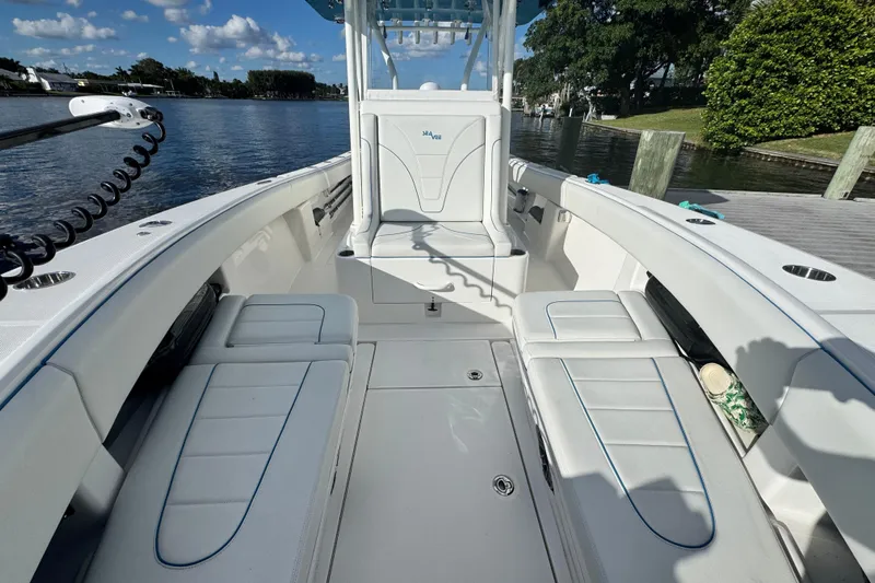 Yacht Photos Pics 2024 SeaVee 290B boat interior with white seating and open deck, docked by the water.