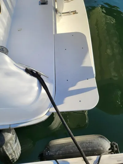 Golden Eagle Yacht Photos Pics 1996 Sea Ray 500 Sundancer swim platform with mooring line and fender in water.