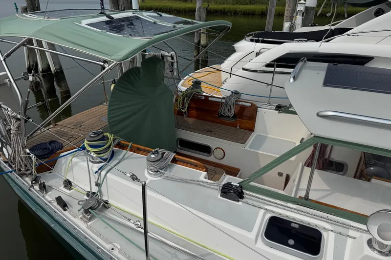 Mara Yacht Photos Pics 1998 Able Apogee 50 sailboat docked, featuring solar panels and green canopy.