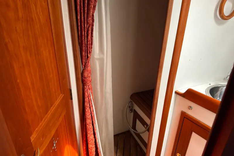 Mara Yacht Photos Pics Interior of 1998 Able Apogee 50 yacht with wooden cabinetry and red curtain.