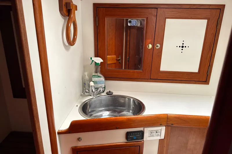Mara Yacht Photos Pics 1998 Able Apogee 50 yacht bathroom with wooden cabinets and stainless steel sink.
