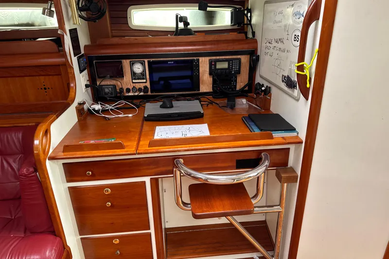 Mara Yacht Photos Pics Navigation station inside a 1998 Able Apogee 50 yacht, featuring wooden desk and instruments.