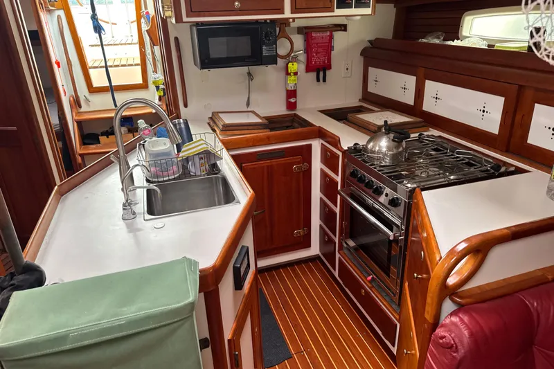 Mara Yacht Photos Pics 1998 Able Apogee 50 yacht kitchen with wooden cabinetry and modern appliances.