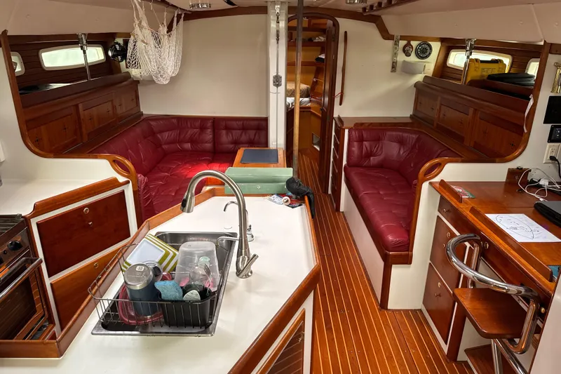 Mara Yacht Photos Pics Interior of 1998 Able Apogee 50 yacht with red leather seating and wooden finishes.