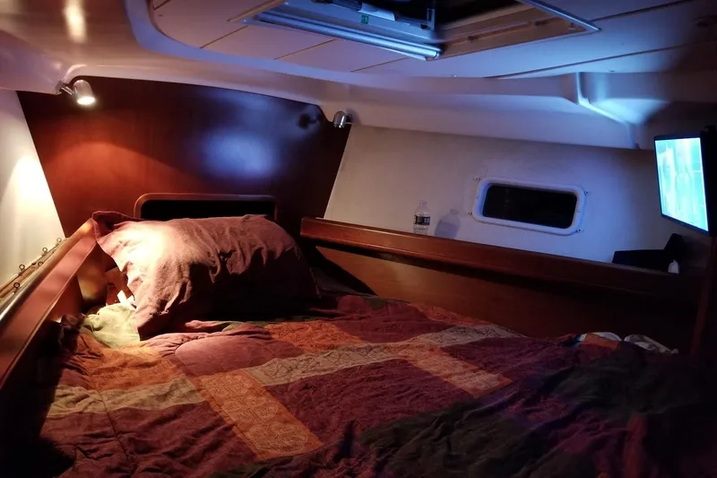  Yacht Photos Pics Cozy cabin interior of 2003 Beneteau Oceanis Clipper 423 sailboat with bed and porthole.