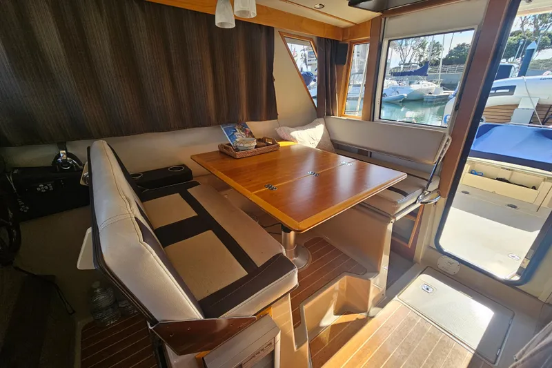 Tuva- B - Lu Yacht Photos Pics Interior of 2015 Cutwater 30 Command Bridge with dining area and marina view.