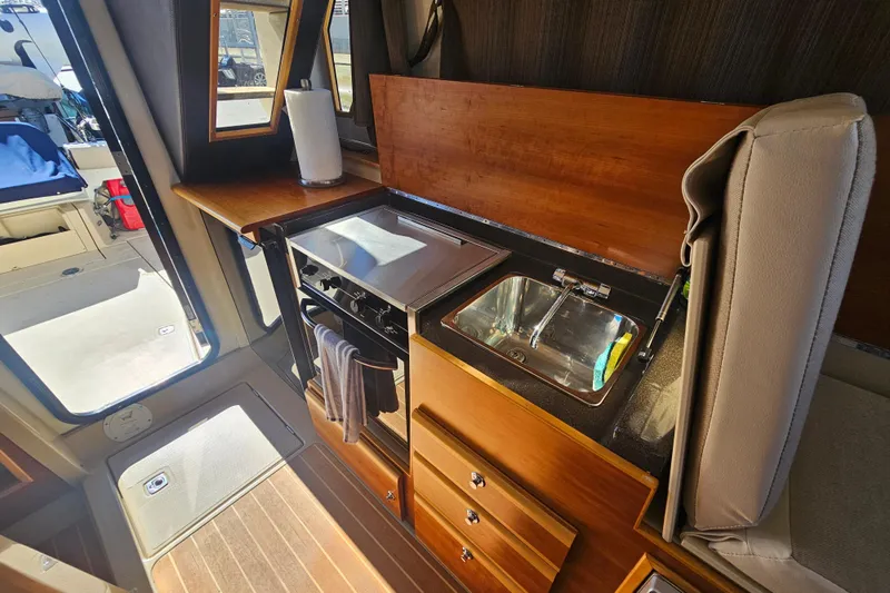 Tuva- B - Lu Yacht Photos Pics Interior of 2015 Cutwater 30 Command Bridge, featuring a compact kitchen with stove and sink.