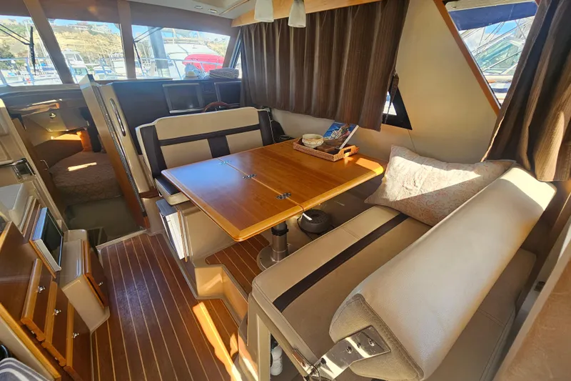 Tuva- B - Lu Yacht Photos Pics Interior of 2015 Cutwater 30 Command Bridge with dining area and wood accents.