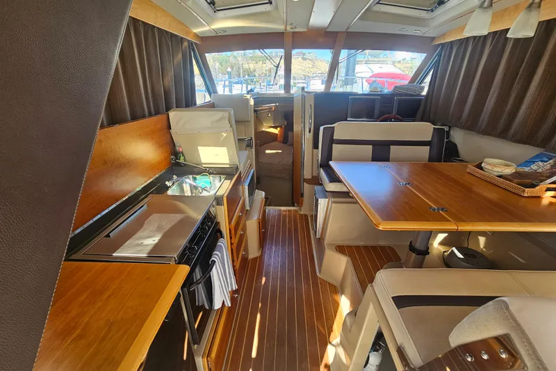 Tuva- B - Lu Yacht Photos Pics Interior of 2015 Cutwater 30 Command Bridge with wood finishes and dining area.