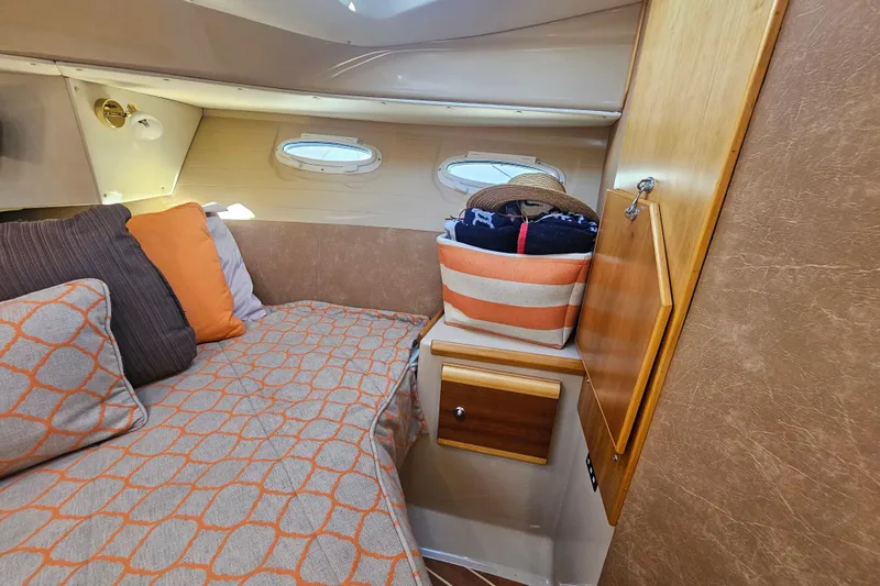 Tuva- B - Lu Yacht Photos Pics Cozy cabin interior of 2015 Cutwater 30 Command Bridge with striped bedding and storage.