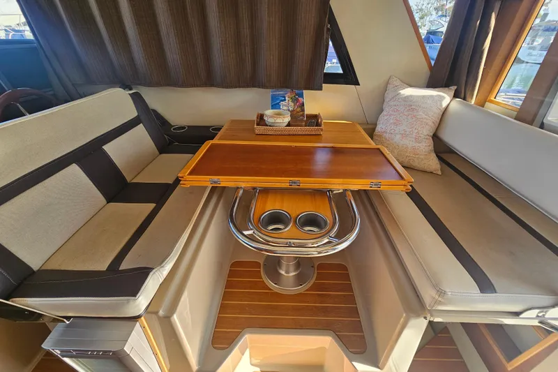 Tuva- B - Lu Yacht Photos Pics Interior of 2015 Cutwater 30 Command Bridge with cozy seating and wooden table.