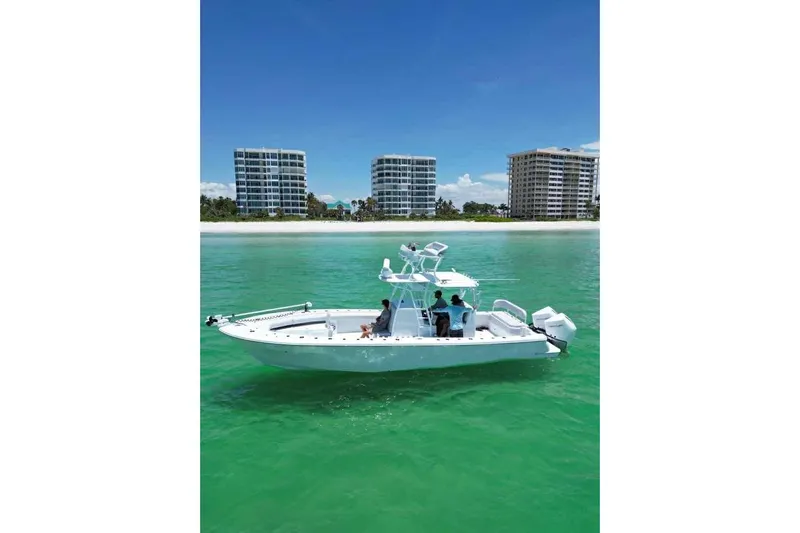 El Viaje Yacht Photos Pics 2023 Andros Offshore 32 boat cruising near beachfront buildings in clear turquoise water.