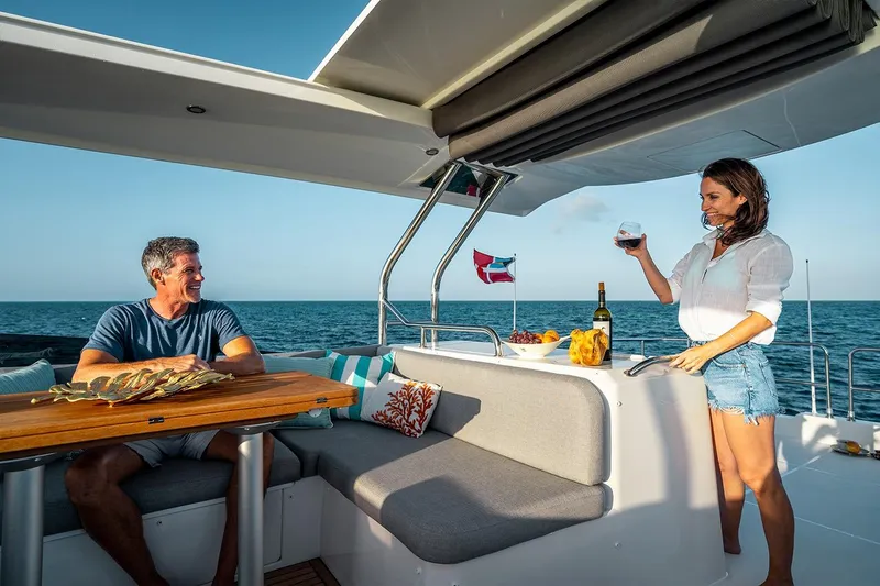  Yacht Photos Pics Couple enjoying drinks on 2026 Beneteau Swift Trawler 48, ocean view in background.