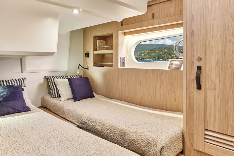  Yacht Photos Pics Interior of 2026 Beneteau Swift Trawler 48 with cozy twin beds and scenic window view.