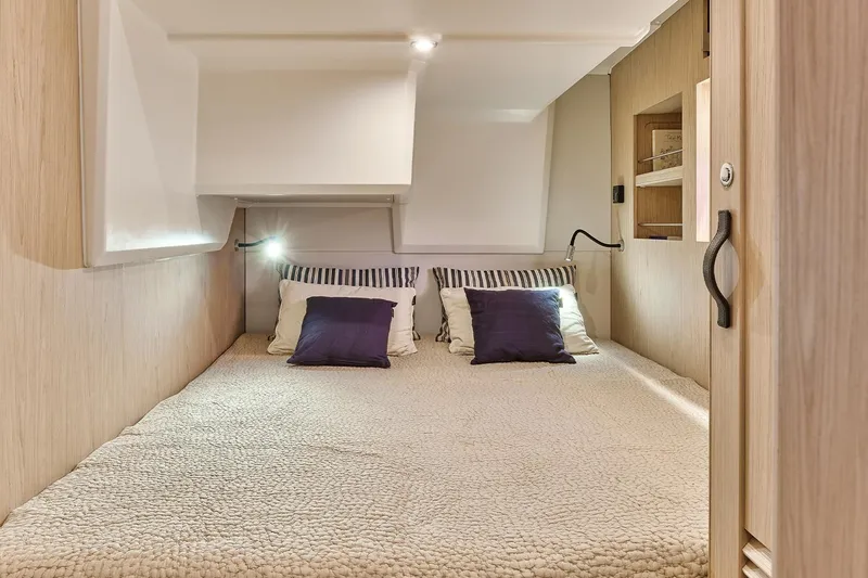  Yacht Photos Pics Cozy bedroom in 2026 Beneteau Swift Trawler 48 with modern design and soft lighting.