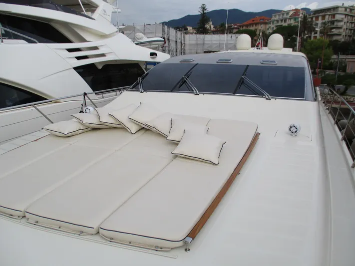 Mr Chic Yacht Photos Pics Luxurious 2001 Riva 84 Cantata yacht with sunbathing cushions on deck, docked in a marina.