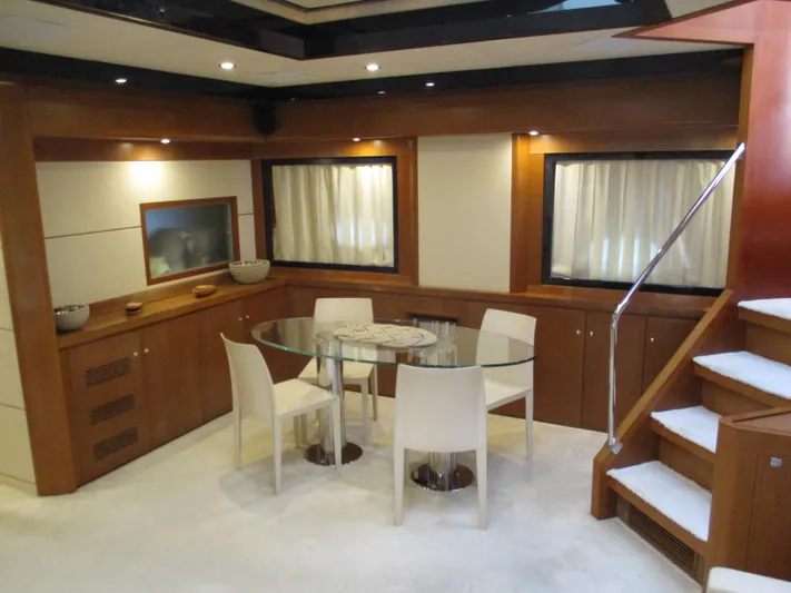 Mr Chic Yacht Photos Pics Luxurious interior of 2001 Riva 84 Cantata yacht with modern dining area and elegant staircase.