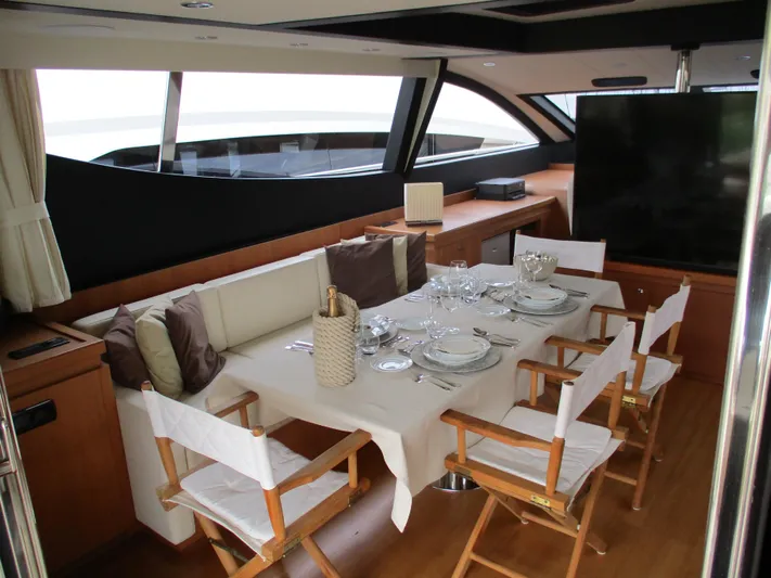 Mr Chic Yacht Photos Pics Luxurious dining area on 2001 Riva 84 Cantata yacht, featuring elegant table setting and comfortable seating.