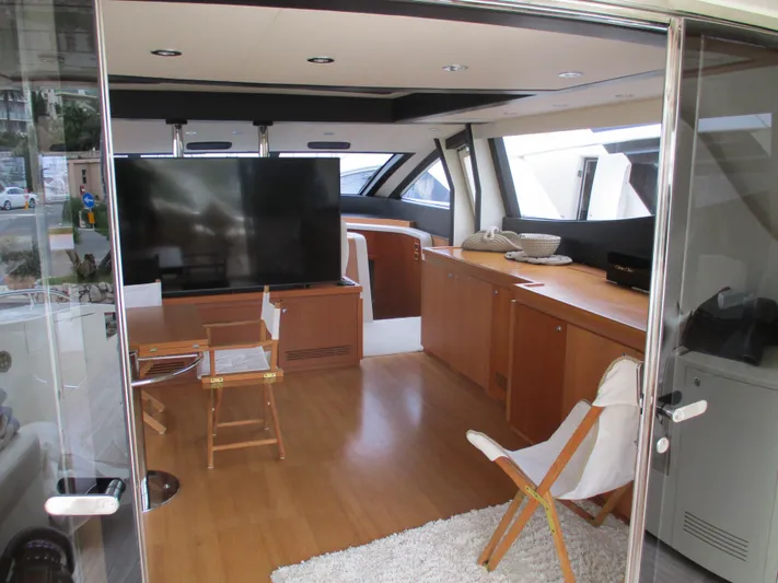 Mr Chic Yacht Photos Pics Luxurious interior of 2001 Riva 84 Cantata yacht with modern furnishings and large TV.